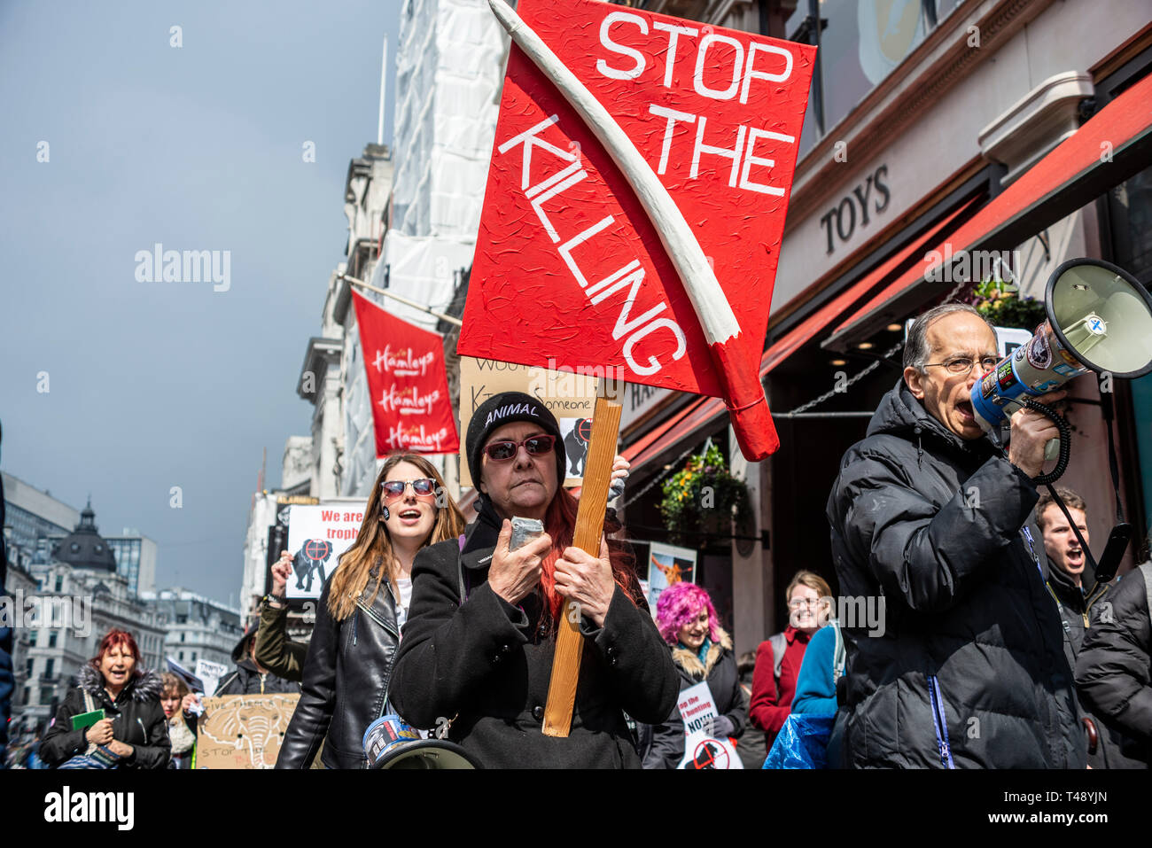 Los manifestantes en una parada la caza de trofeos y la protesta del comercio de marfil, Londres, Reino Unido. Letrero de colmillo de elefante Foto de stock