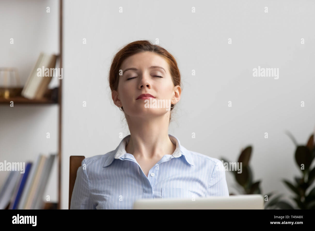 Tome la empresaria relajada bocanada de aire fresco en el lugar de trabajo Foto de stock