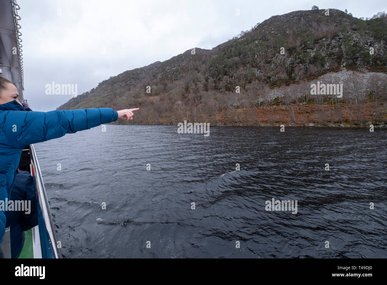 Turista buscando monstruo Nessie durante un crucero en barco en el Lago Ness, en las Tierras Altas de Escocia, Escocia, Reino Unido, Europa Foto de stock