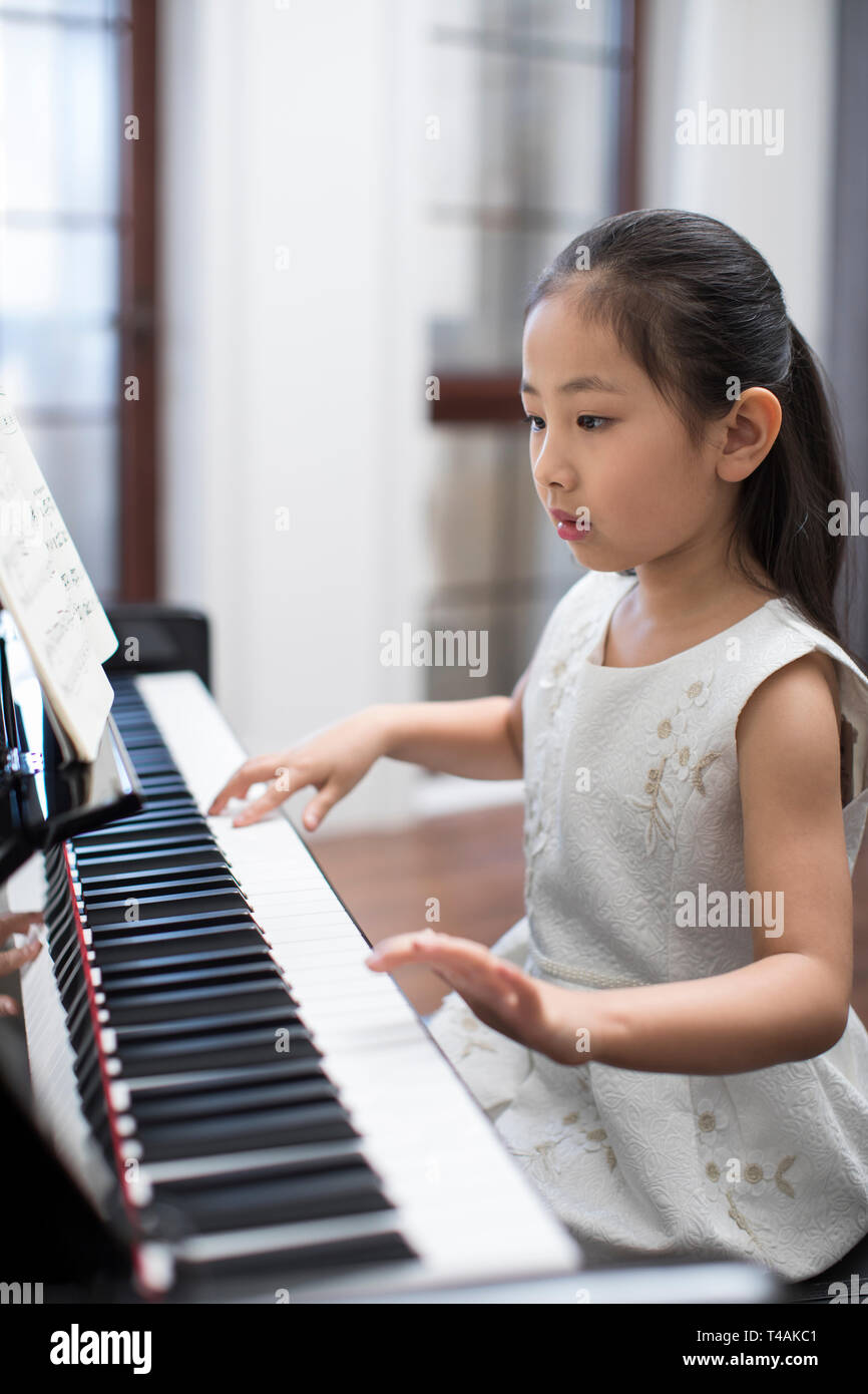 Feliz niña tocando el piano Fotografía de stock - Alamy