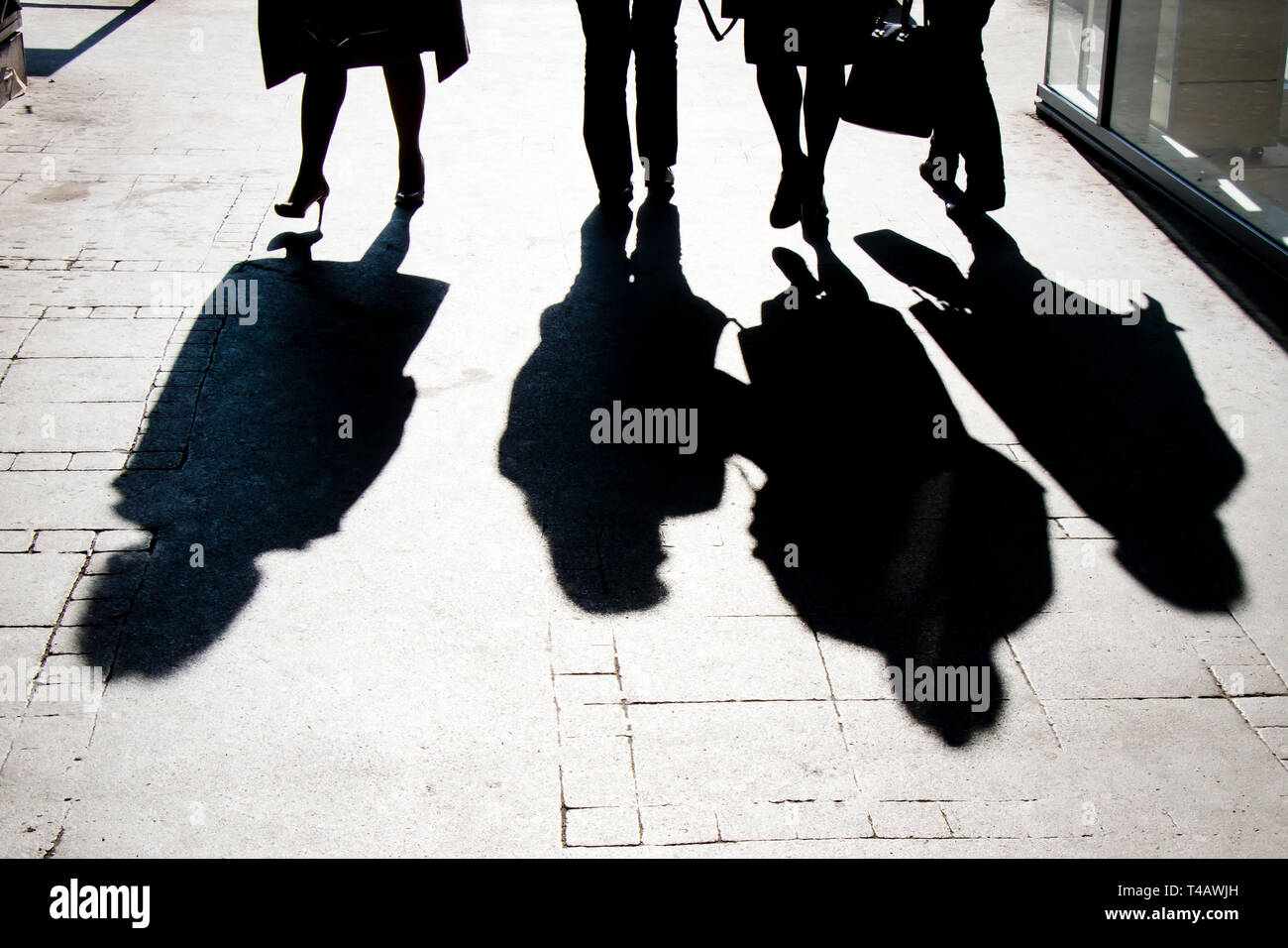 Sombra borrosa silueta de la gente caminando en la calle peatonal de la ciudad en blanco y negro de alto contraste Foto de stock