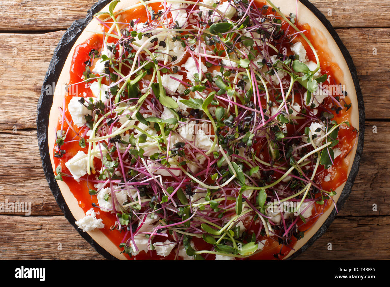 Dieta pizza vegetariana con queso feta y micro mix fresco verde de cerca en la tabla superior horizontal vista desde arriba Foto de stock