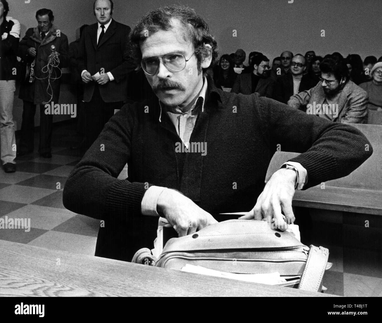 El escritor Günter Wallraff en el banquillo de los acusados antes de la audiencia en la corte comienza el 10 de diciembre de 1975. El escritor y autor de Colonia de 'informes' indeseables, Günter Wallraff (33), tenía que responder a cargos en el tribunal de magistrados de Colonia el miércoles, 10 de diciembre de 1975. Las acusaciones de la fiscalía a él con la falsificación de documentos y uso indebido de documentos de identidad. Con un nombre equivocado, Wallraff había trabajado como mensajero en la preocupación de seguros Gerling en Colonia en 1973. Él había autorizado a sí mismo con tarjetas de seguro de pensiones por invalidez y bajo su nombre equivocado y publicó sus experiencias más adelante en la b Foto de stock