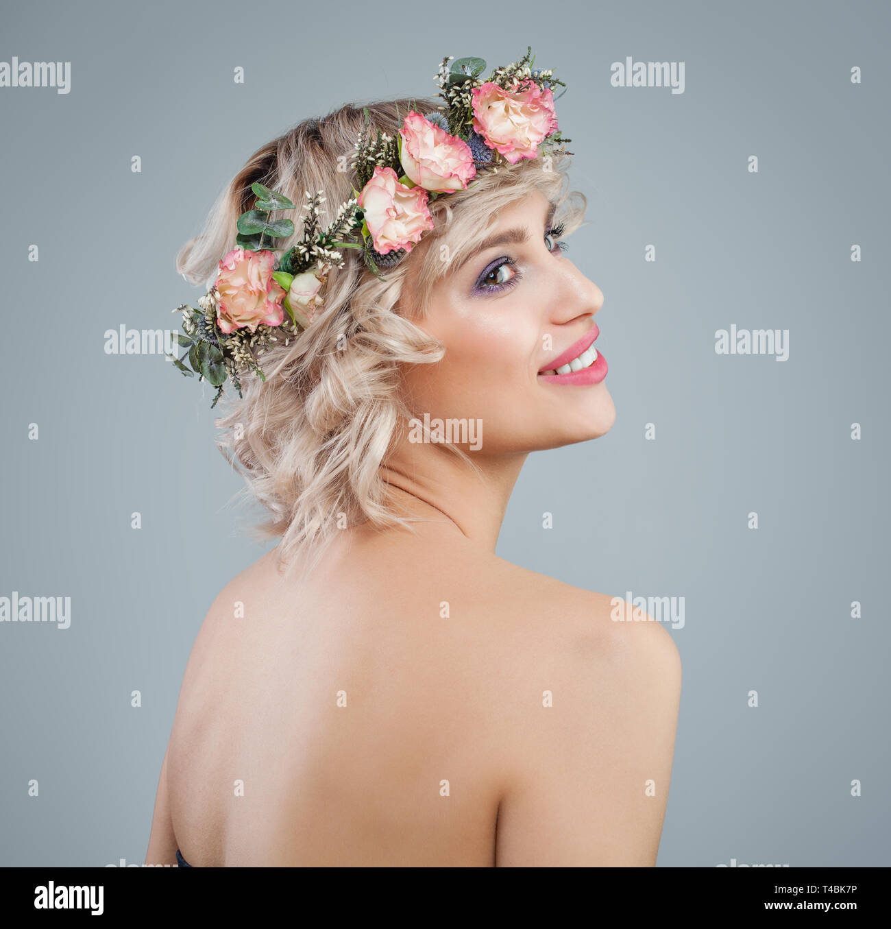 Feliz Modelo En Flores Retrato Bella Mujer Con Cabello Rizado Rubio Corto Y Maquillaje Sobre Fondo Azul Fotografia De Stock Alamy