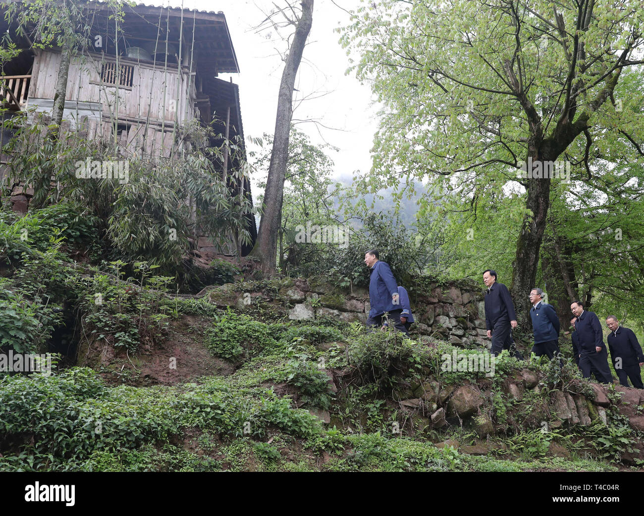 Chongqing, China. 15 abr, 2019. El Presidente chino Xi Jinping, también secretario general del Partido Comunista de China y presidente del Comité Central de la Comisión Militar Central, camina a la casa de un aldeano para aprender acerca de los progresos de la mitigación de la pobreza y en la solución de problemas, incluida la destacada reunión la necesidad básica de alimentos y ropa y garantizar la educación obligatoria, atención médica básica y la vivienda segura, en la aldea de Huaxi Shizhu Tujia Condado autónoma del sudoeste de China, Chongqing, 15 de abril de 2019. Crédito: Xinhua/Alamy Live News Foto de stock