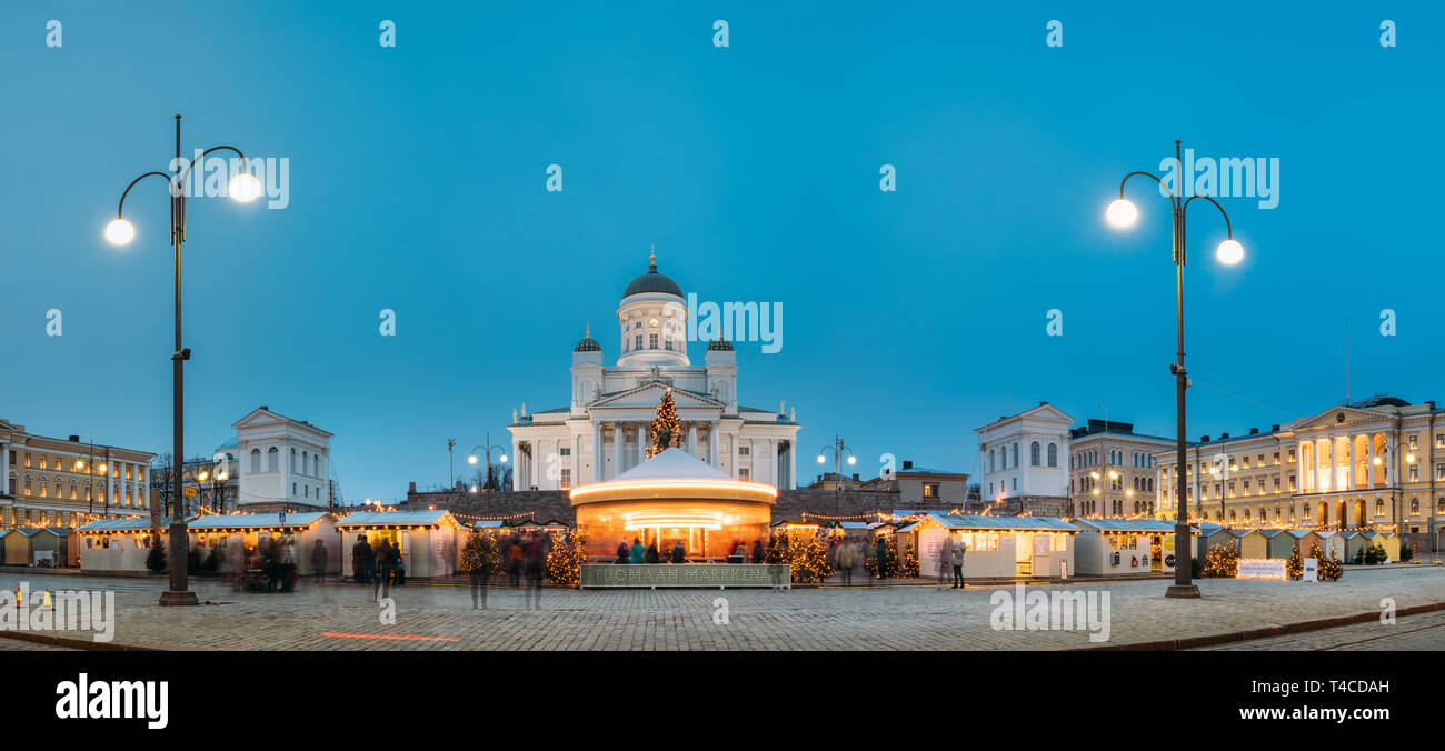 Helsinki, Finlandia - 11 de diciembre de 2016: Mercado de Navidad en la Plaza del Senado Con Holiday carrusel y famoso monumento es la Catedral Luterana en invierno Nig Foto de stock