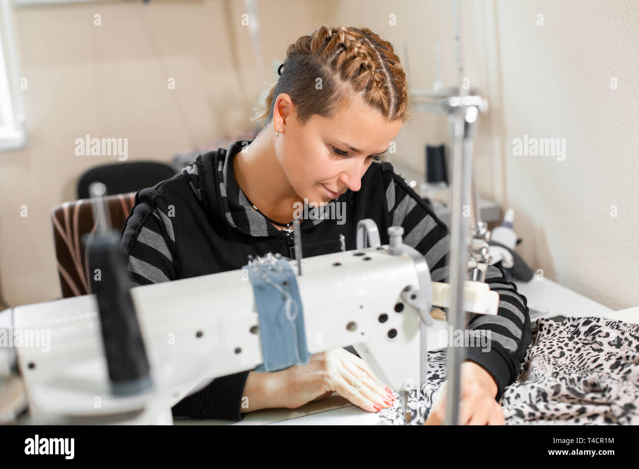 Costurera cosiendo a máquina, retrato. Hembra adaptar material pegado en el lugar de trabajo. Preparando el tejido para hacer ropa. Confección de prendas de vestir, industr Fotografía de stock - Alamy Costurera cosiendo a máquina, retrato. Hembra adaptar material pegado en el lugar de trabajo. Preparando el tejido para hacer ropa. Confección de prendas de vestir, industr Fotografía de stock - Alamy