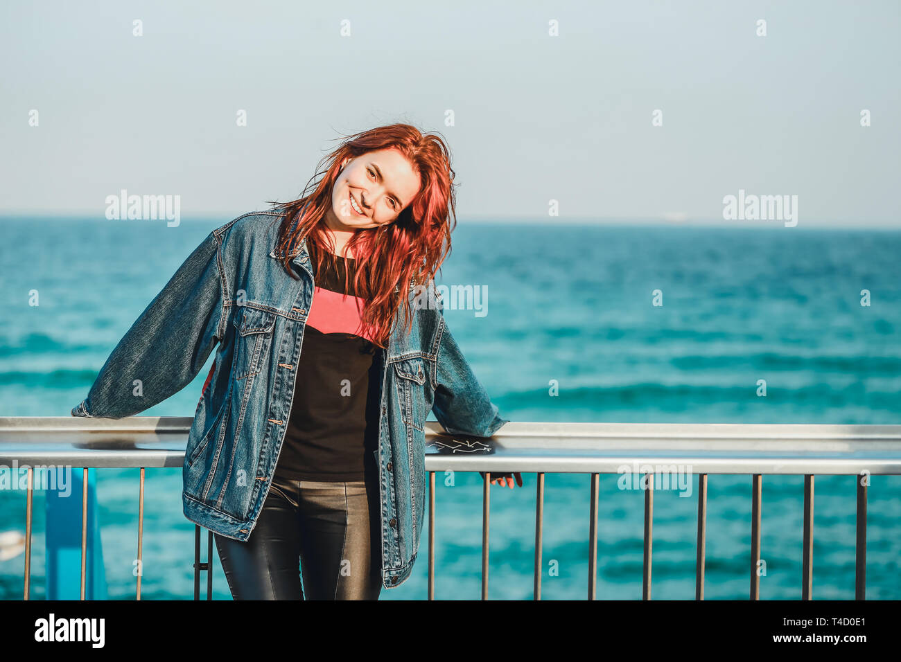 Retrato de una joven hermosa chica pelirroja en el fondo del mar. Ella se siente feliz y libre, ella tiene una hermosa sonrisa de dientes blancos y un pl Foto de stock