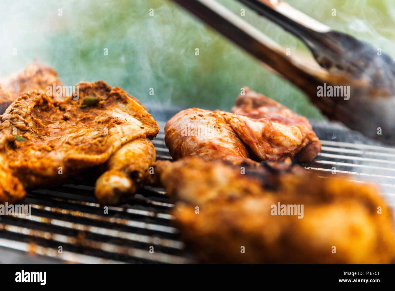 Cocinero de casa controlar cada pieza de pollo asado marinado con cuidado. Foto de stock