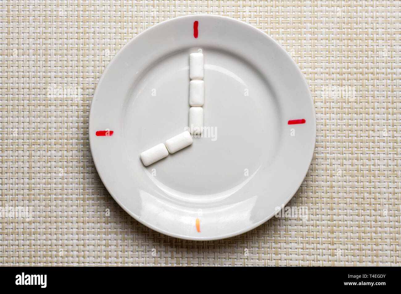 Limpieza de los dientes de la rotura. Tiempo para el cepillado de dientes durante el trabajo o comer. Símbolo de reloj en la placa. Concepto de higiene bucal con pasta de dientes, toothbru Foto de stock