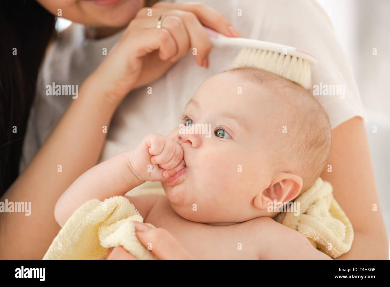 Mamá peine a un bebé recién nacido con un cepillo especial para el cabello.  Concepto de maternidad. Higiene del bebé Fotografía de stock - Alamy