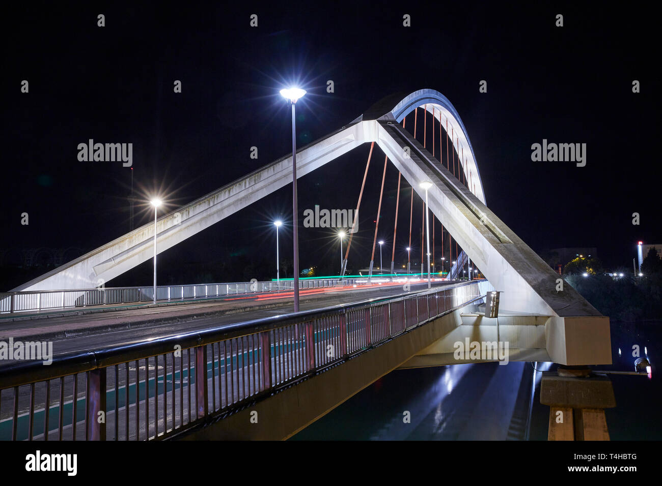 El "Puente de la Barqueta' Puente en Sevilla iluminada por la noche Foto de stock