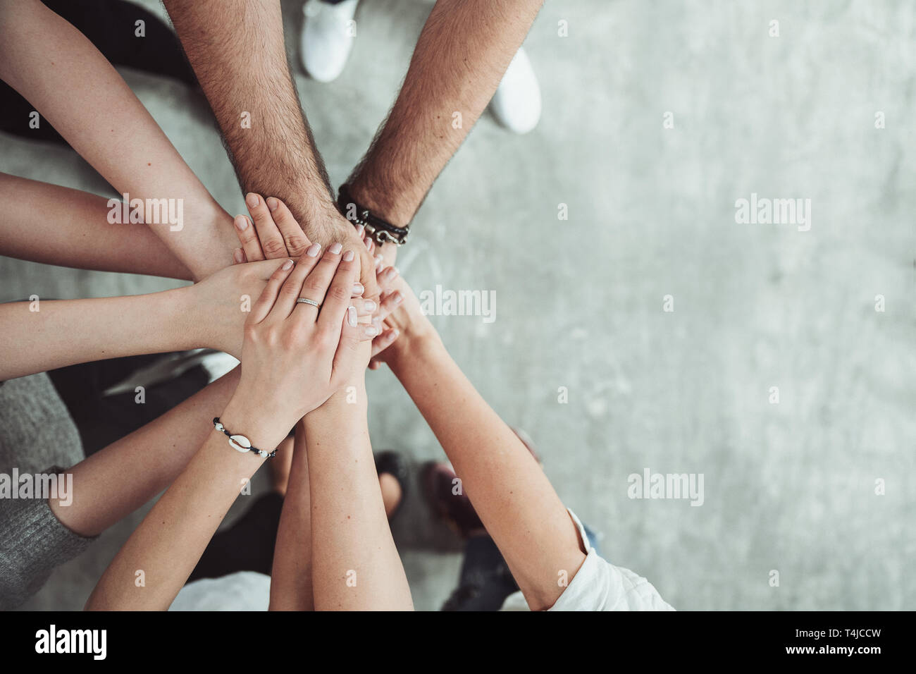 El trabajo en equipo, la unidad, el concepto de grupo de amigos ponen sus manos junto con espacio de copia Foto de stock