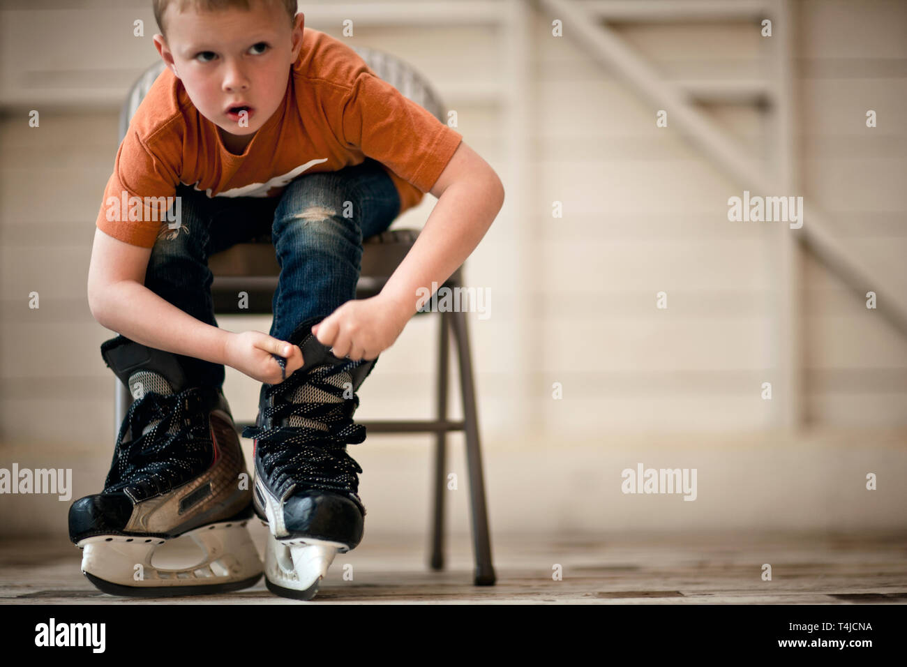 Joven atar los cordones en sus patines para hielo. Foto de stock