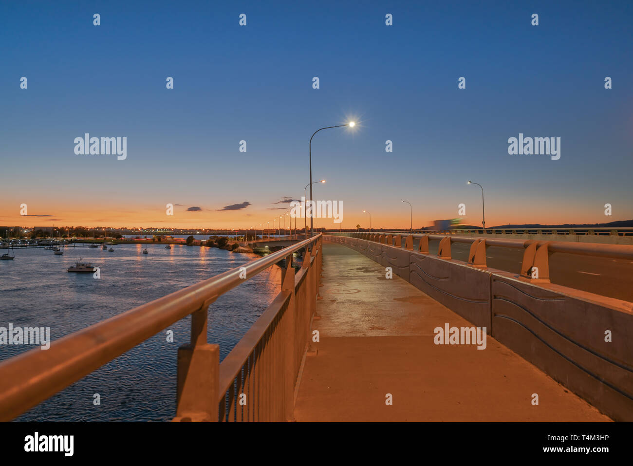 El Puerto de Tauranga Puente ruta de transporte por carretera y vía peatonal y ciclista con resplandor de ciclistas y pasando las luces del vehículo Foto de stock