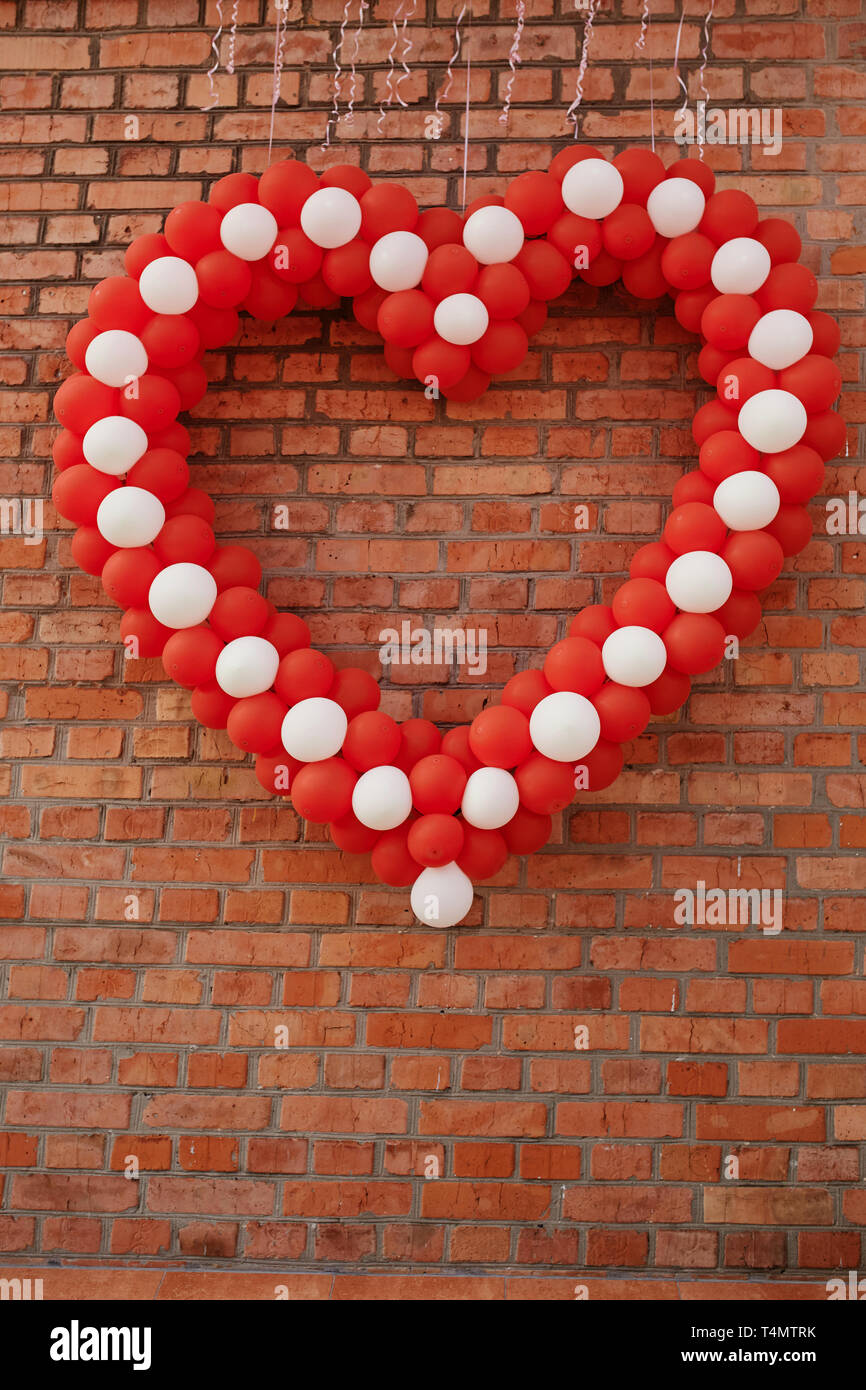 vacío Corredor erosión Concepto para celebrar el Día de San Valentín. corazón de globos contra el  fondo de la pared. El diseño de los globos es blanco-rojo con un gran  corazón en el cent Fotografía