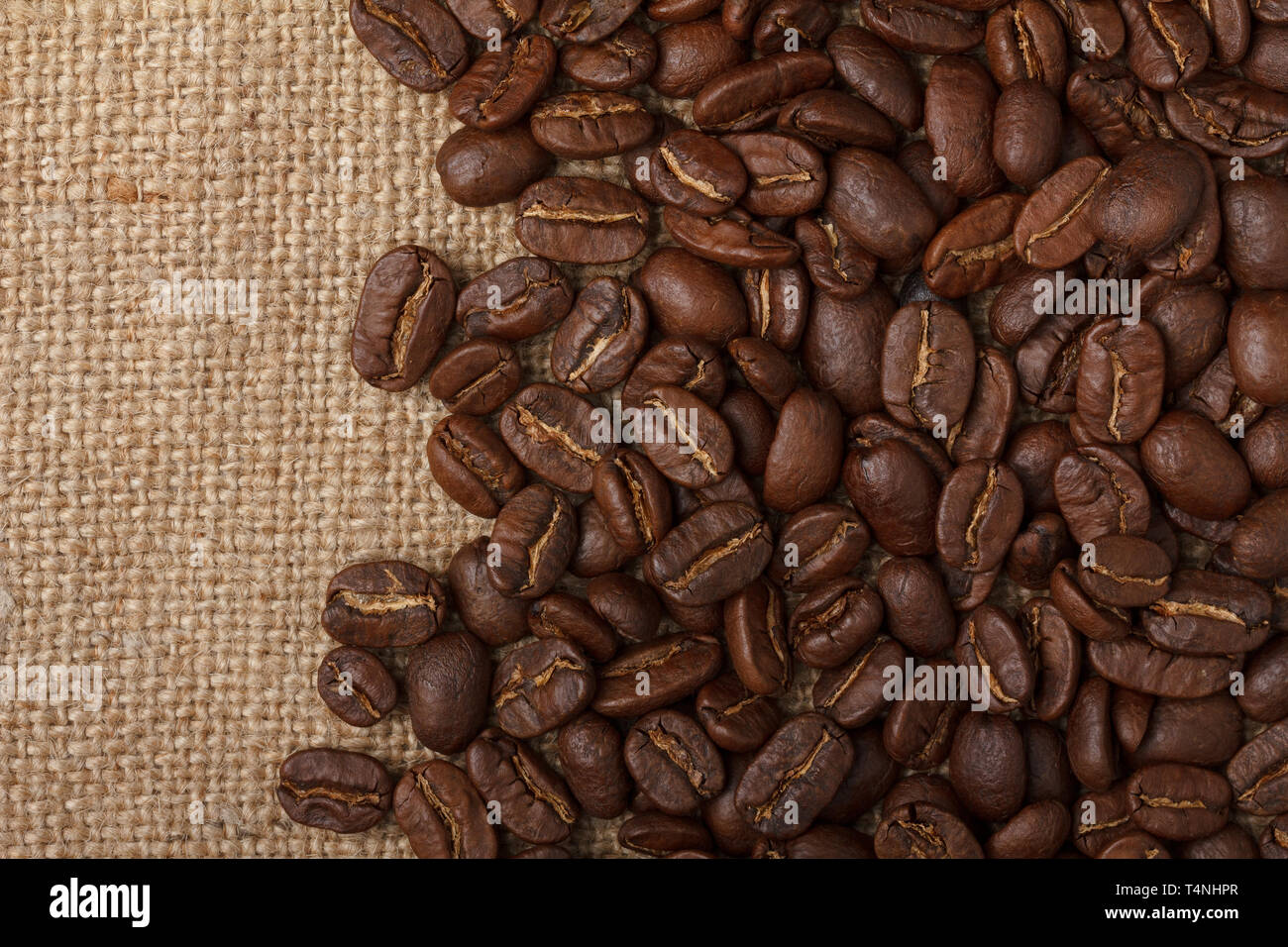 Los granos de café sobre fondo de tela de saco Foto de stock