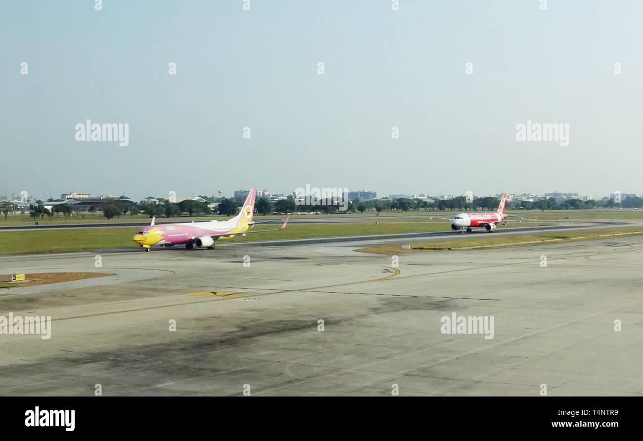 Aviones de Nok Air y AirAsia, 2 principales líneas aéreas de bajo coste en Asia, están siguiendo uno al otro en la pista de aterrizaje, después de sus vuelos. Foto de stock
