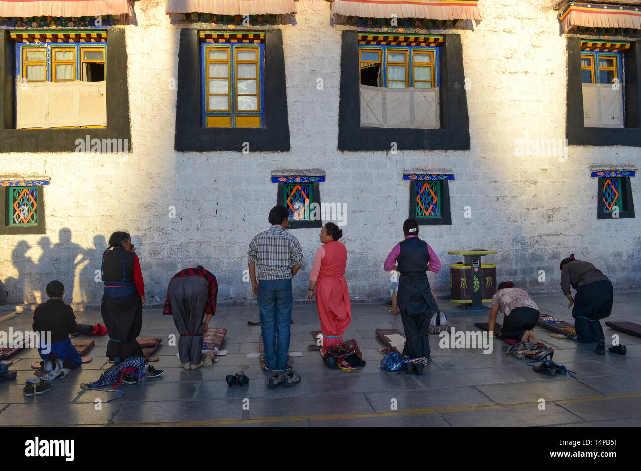 Los peregrinos orando afuera del Templo de Jokhang, el templo más sagrado del budismo tibetano en Lhasa, Tibet Foto de stock