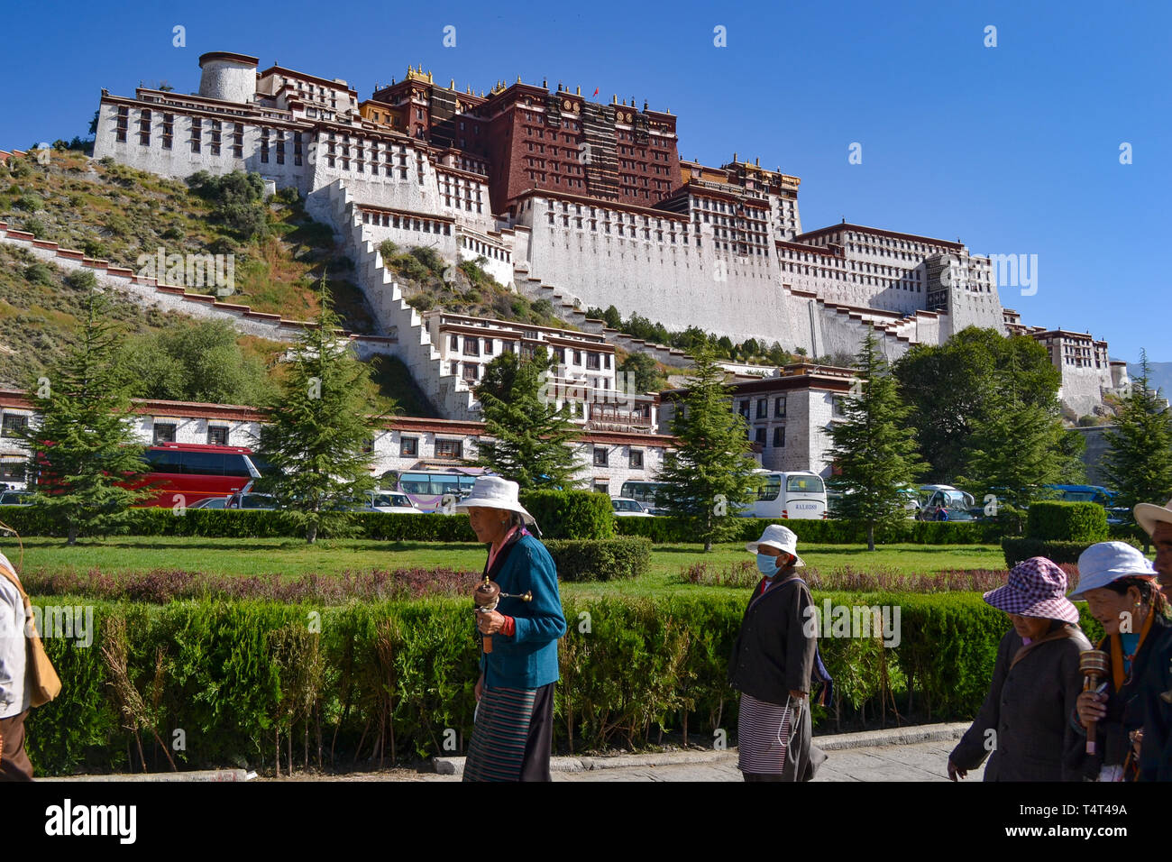 Los peregrinos del Budismo Tibetano caminando delante del Palacio Potala en Lhasa, Tibet Foto de stock