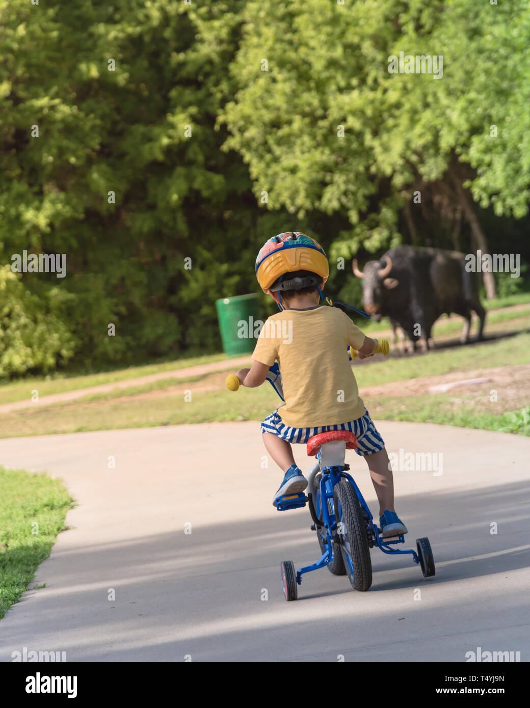 Vista trasera del niño asiático boy triciclo de equitación en el parque  natural cerca de Dallas, Texas, EE.UU. Niño Saludable Bicicleta con Casco,  corto y zapatillas de deporte en park conc Fotografía
