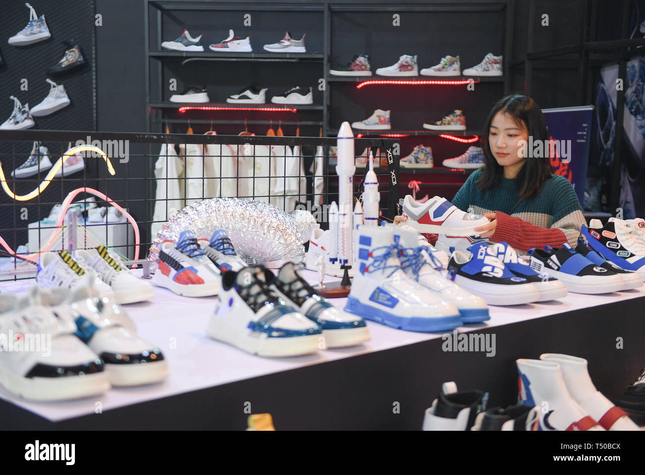 Jinjiang, provincia de Fujian de China. 19 abr, 2019. Un comerciante mira  zapatos personalizados a través de pedidos en línea durante el siglo  Jinjiang calzado y la 4ª Exposición Internacional de la