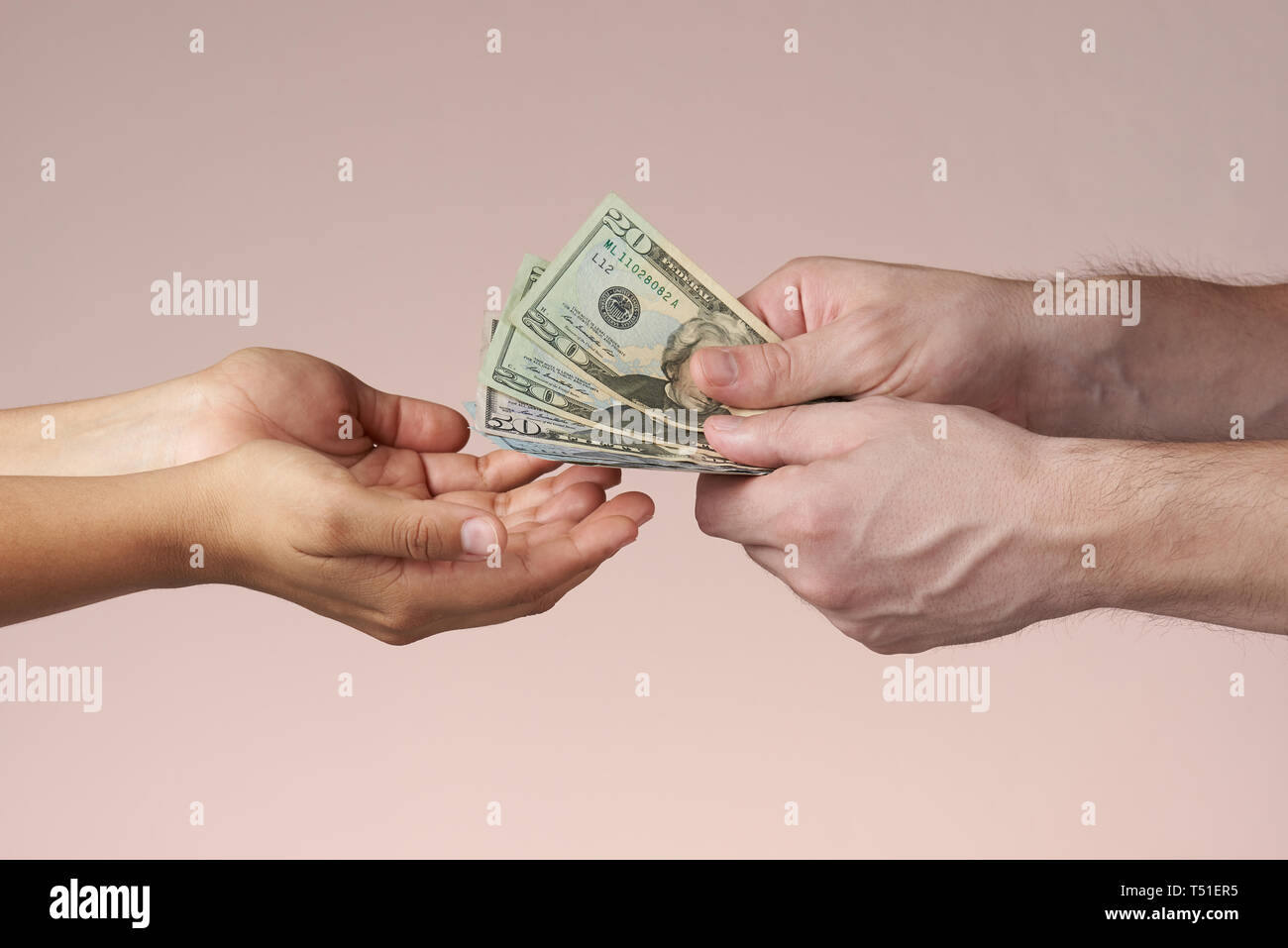 Entrega de billetes de dólar. Dar dinero a alguien. Manos aisladas dando dólares. Foto de stock