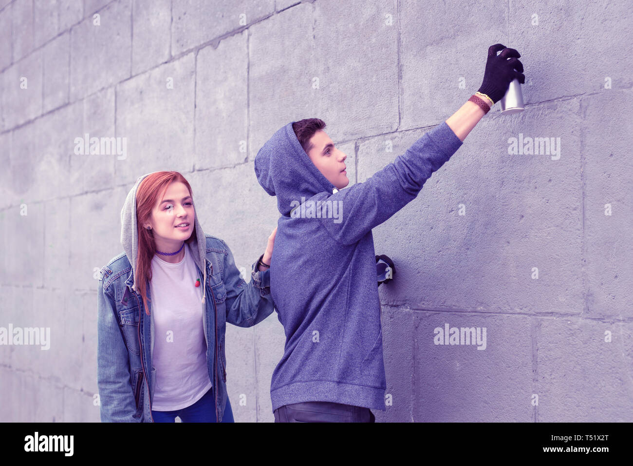 Peligroso joven ciudad para colorear las paredes con pinturas de spray Foto de stock
