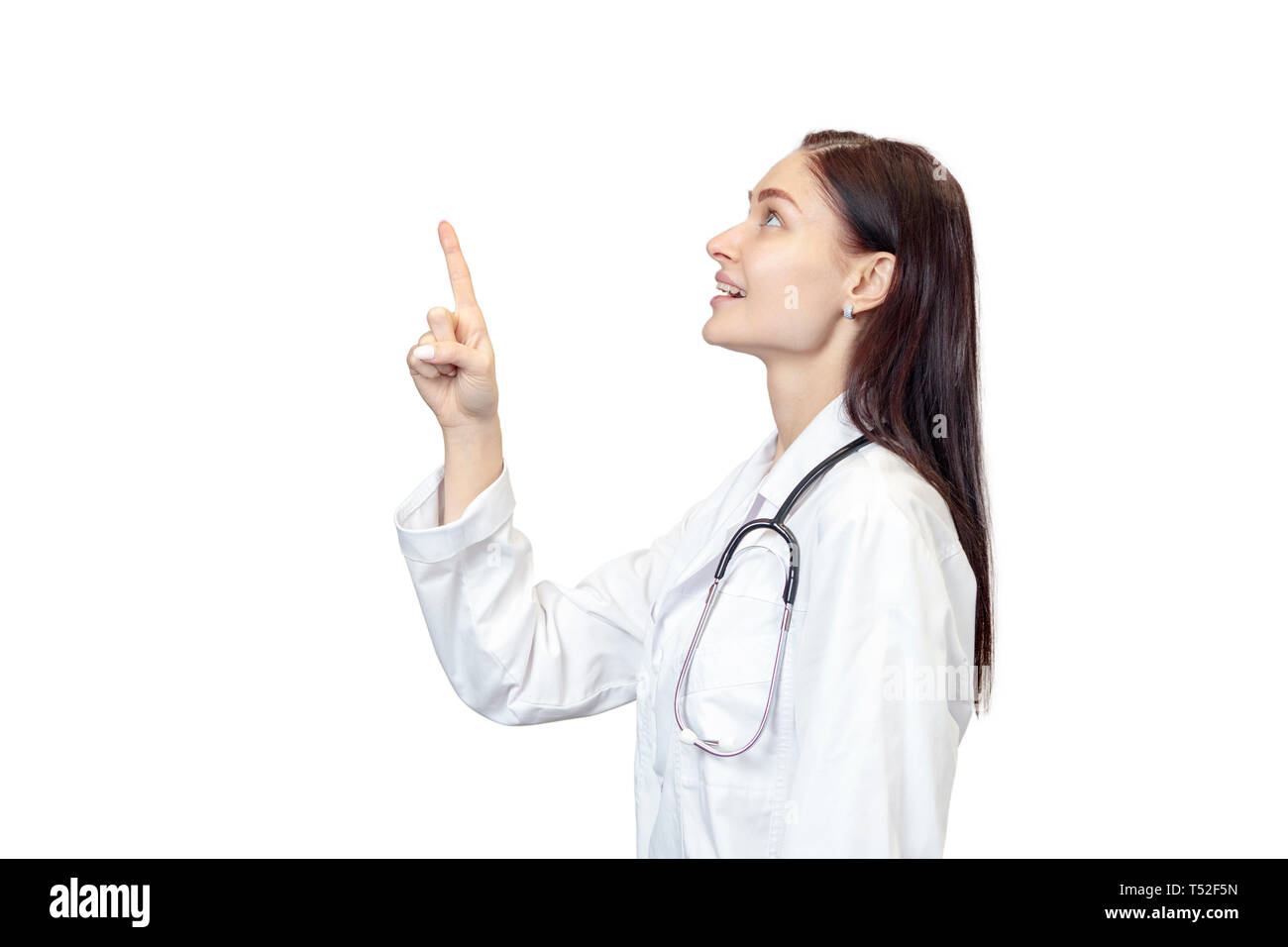 Doctor está lateralmente, apunta un dedo arriba y se ve de la misma manera, aislado sobre fondo blanco. Foto de stock
