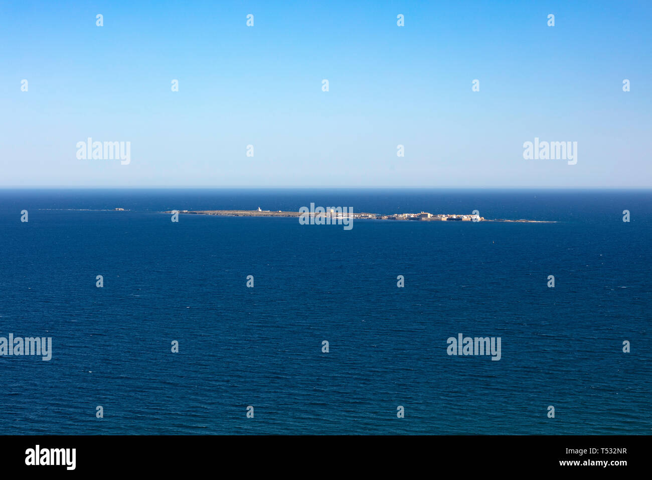 Vista panorámica de la isla de Tabarca desde el faro de Santa Pola, en Alicante, España, en un intenso azul del mar Mediterráneo y el cielo claro Foto de stock