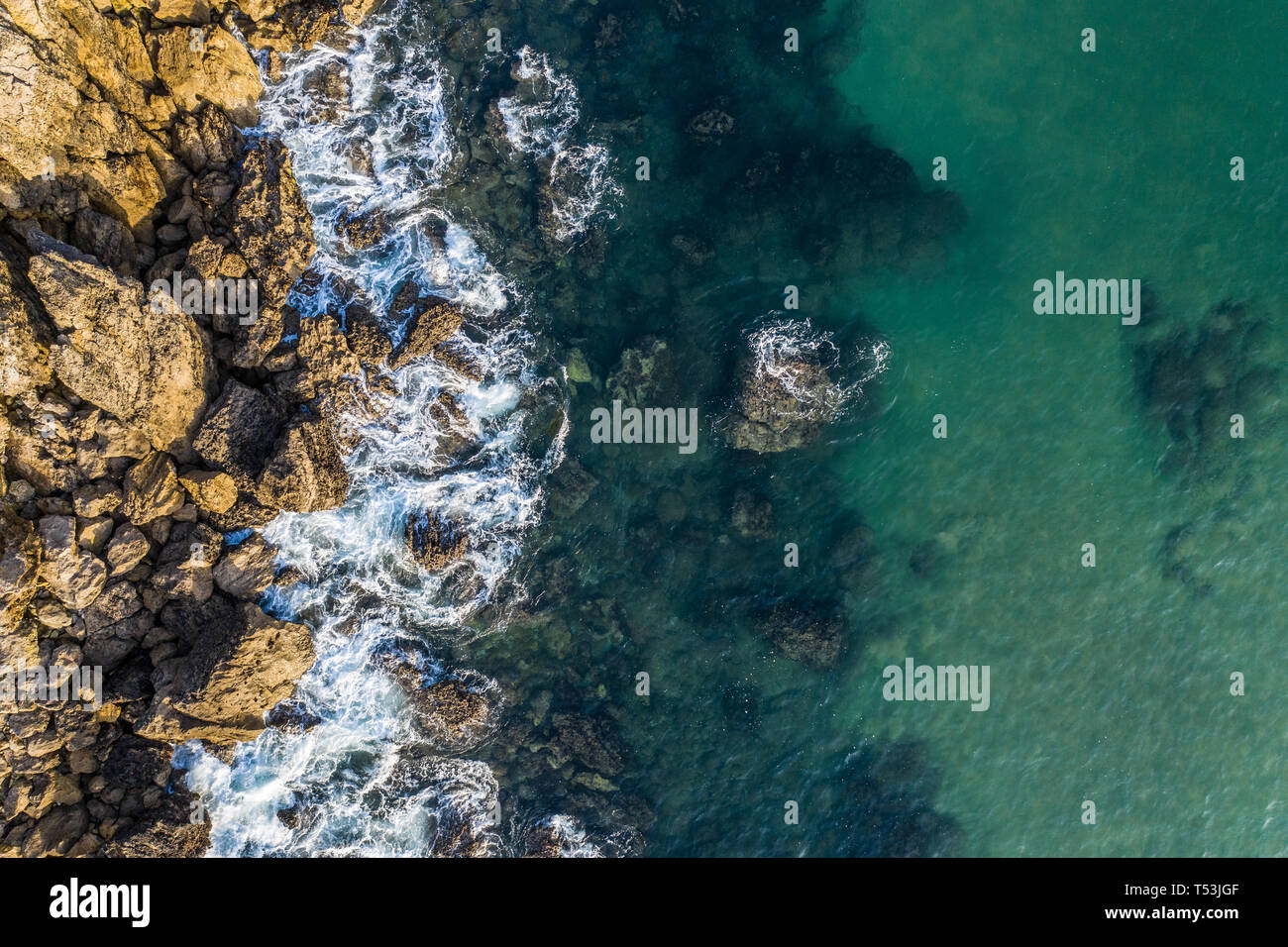 Olas rompiendo en los arrecifes y la costa de Sonabia, España, mar Cantábrico - drone vista aérea Foto de stock