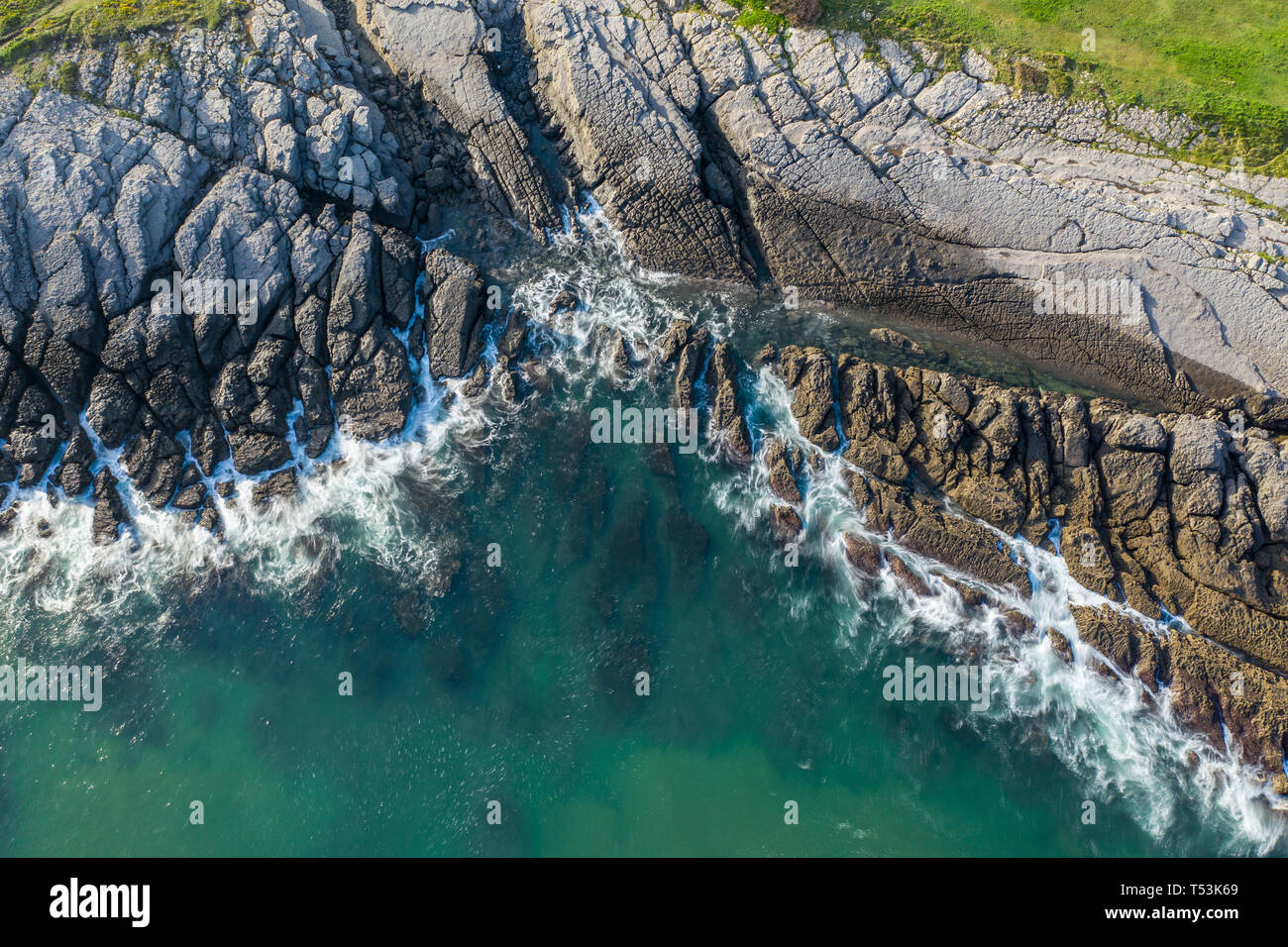 Olas rompiendo en los arrecifes y la costa de Sonabia, España, mar Cantábrico - drone vista aérea - exposición larga Foto de stock