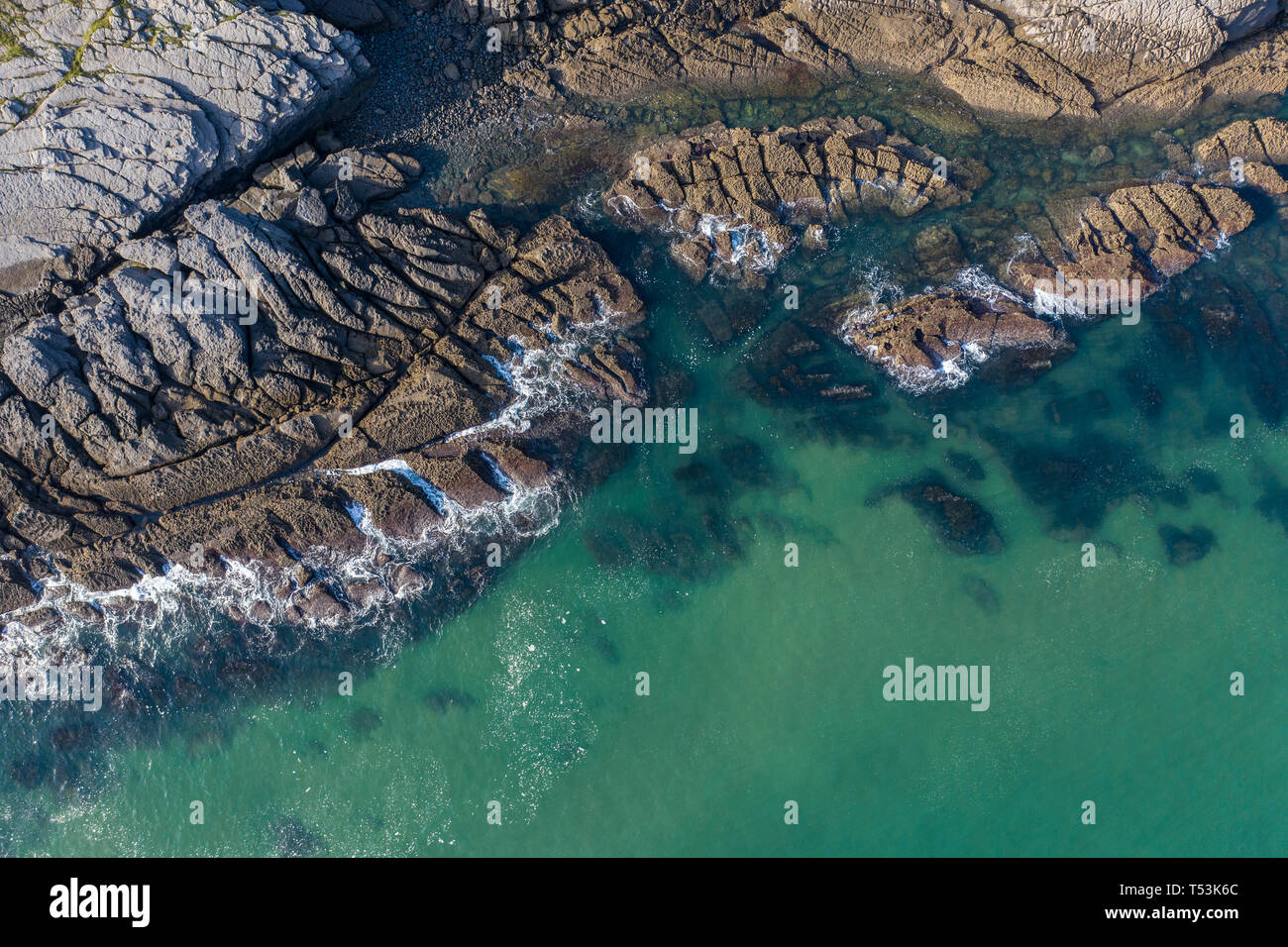 Olas rompiendo en los arrecifes y la costa de Sonabia, España, mar Cantábrico - drone vista aérea Foto de stock