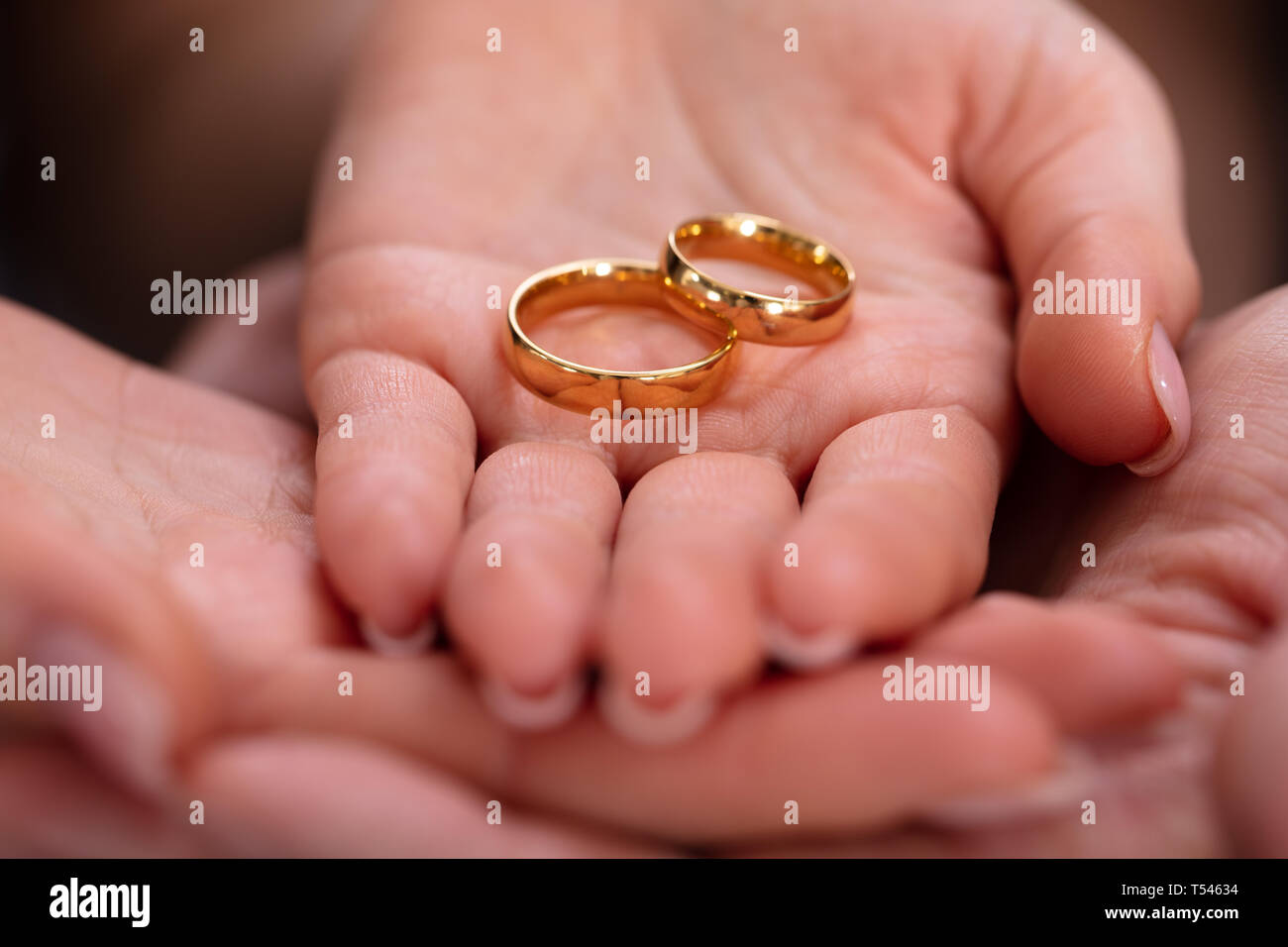 La mano del hombre y de la mujer con un par de anillos de compromiso de oro Fotografía de stock Alamy
