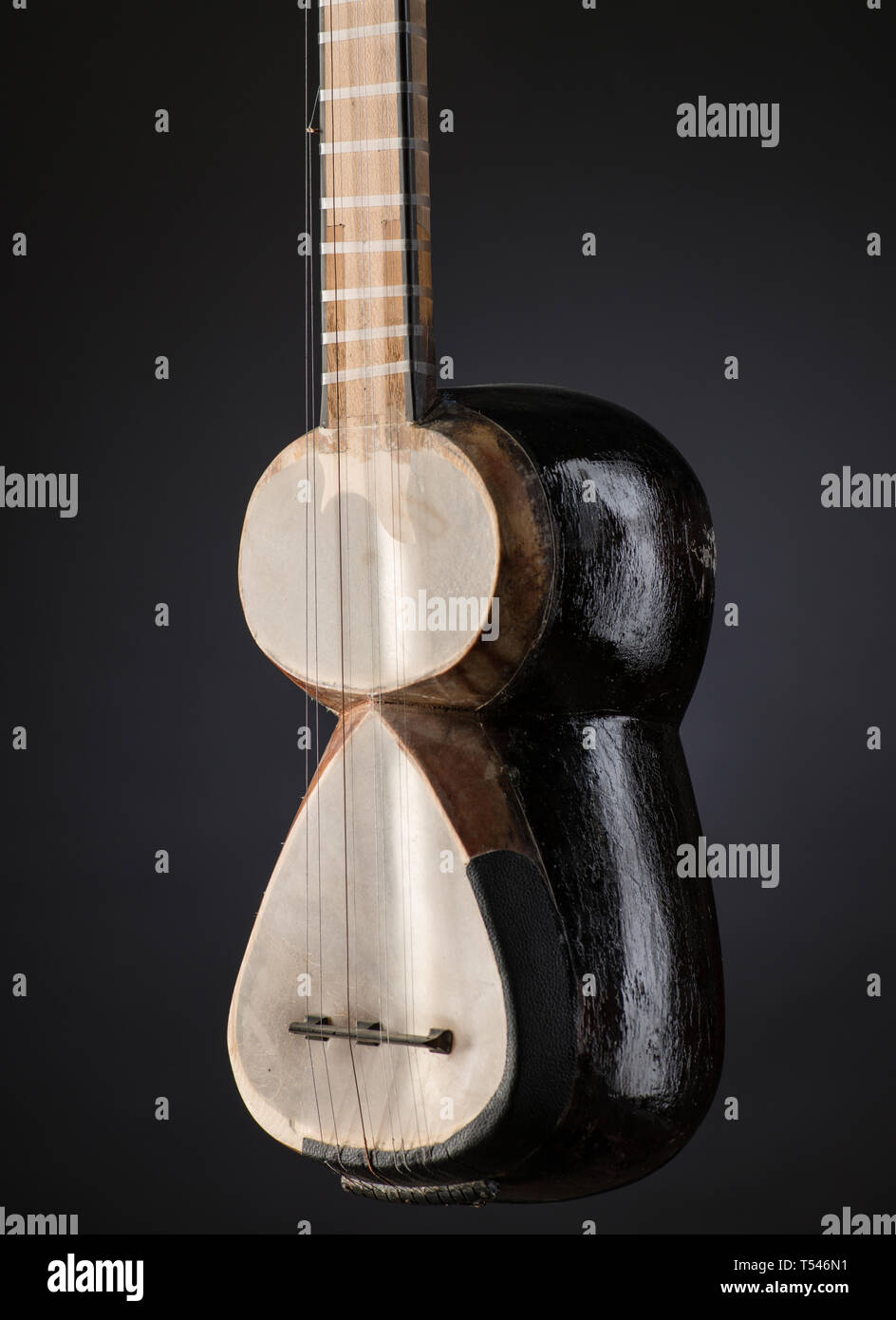 La parte asiática antigua instrumentos musicales de cuerda sobre fondo  negro con retroiluminación Fotografía de stock - Alamy