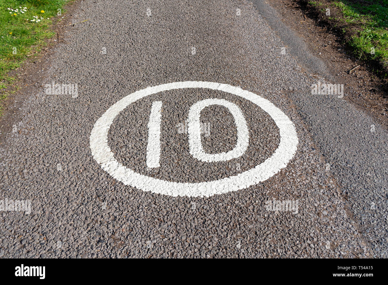 Límite de velocidad de 10 MPH signo pintado sobre la superficie de la carretera Foto de stock