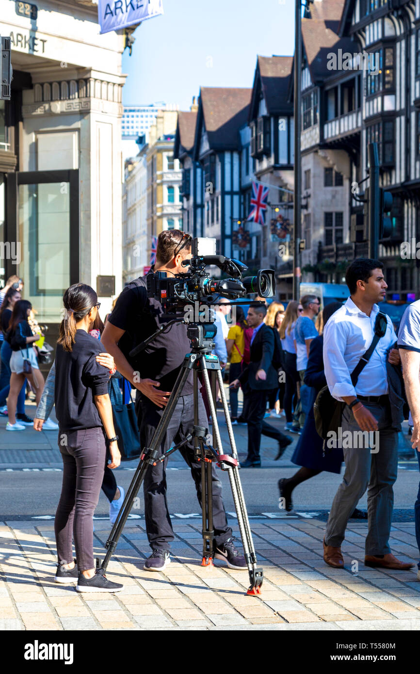El hombre de la cámara filmando en la calle Regent Street, Londres, Reino Unido) Foto de stock