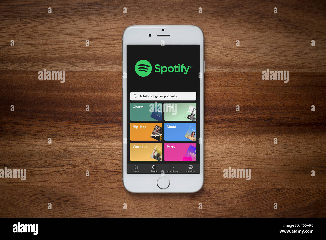 Un iPhone que muestra el sitio web de Spotify descansa sobre una mesa de madera normal (uso Editorial solamente). Foto de stock