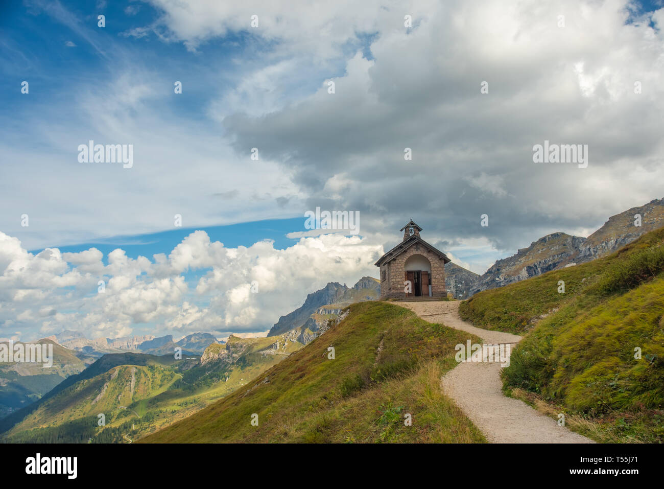 Paisaje de montaña con trail, verdes prados y Passo Pordoi refudjio, dolomitas, Alpes, Italia Foto de stock