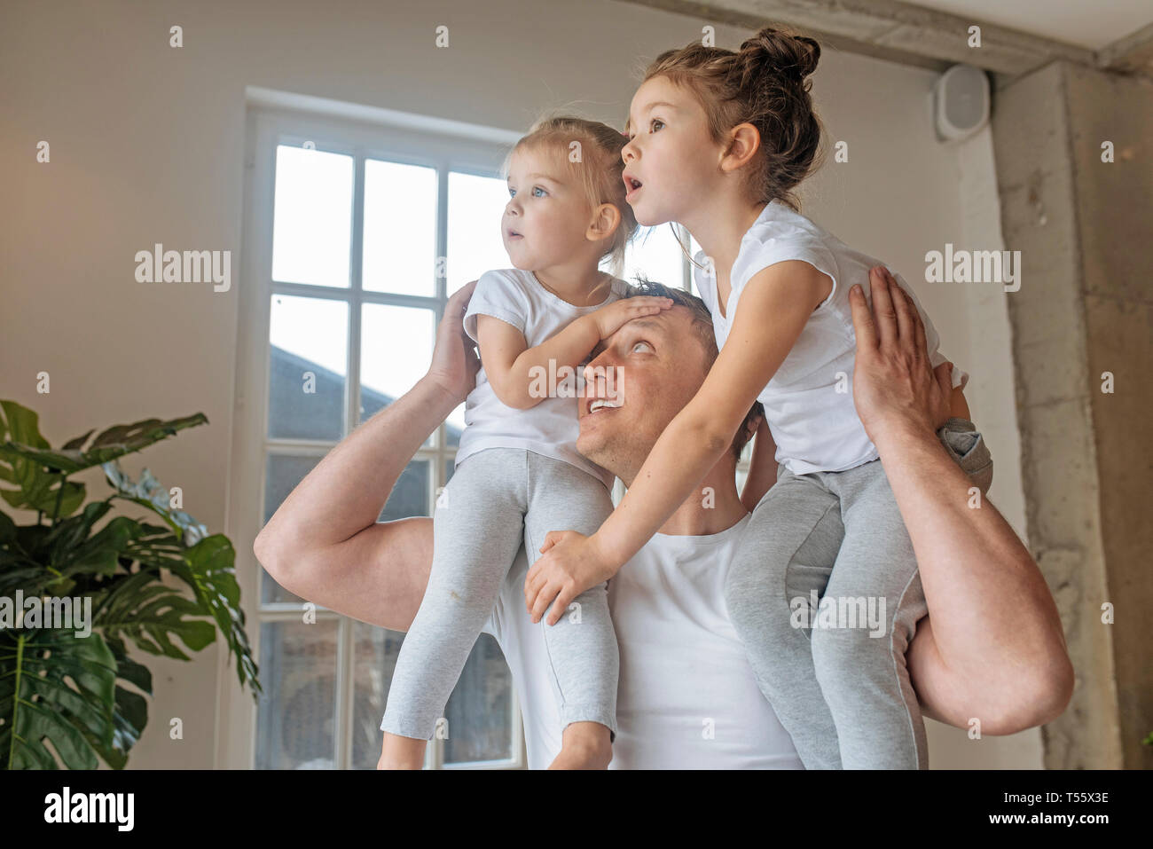 Padre con sus hijas sobre sus hombros Foto de stock