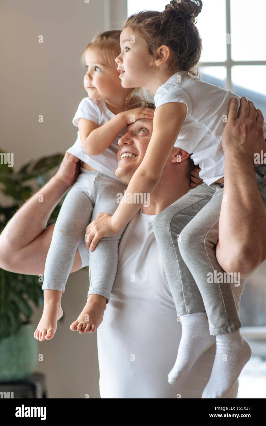 Padre con sus hijas sobre sus hombros Foto de stock