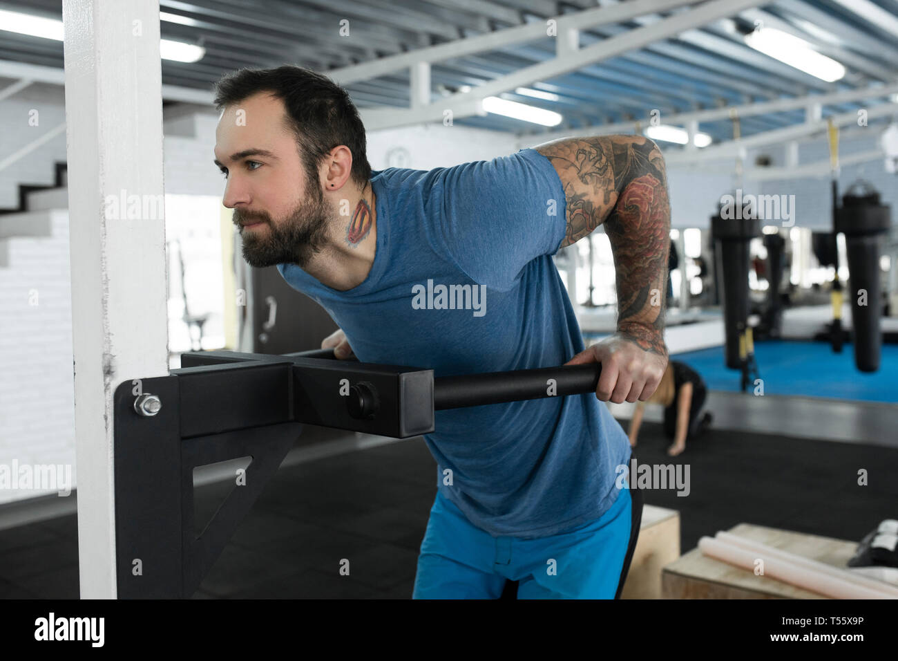 Mitad hombre adulto con máquina de ejercicio en el gimnasio Foto de stock
