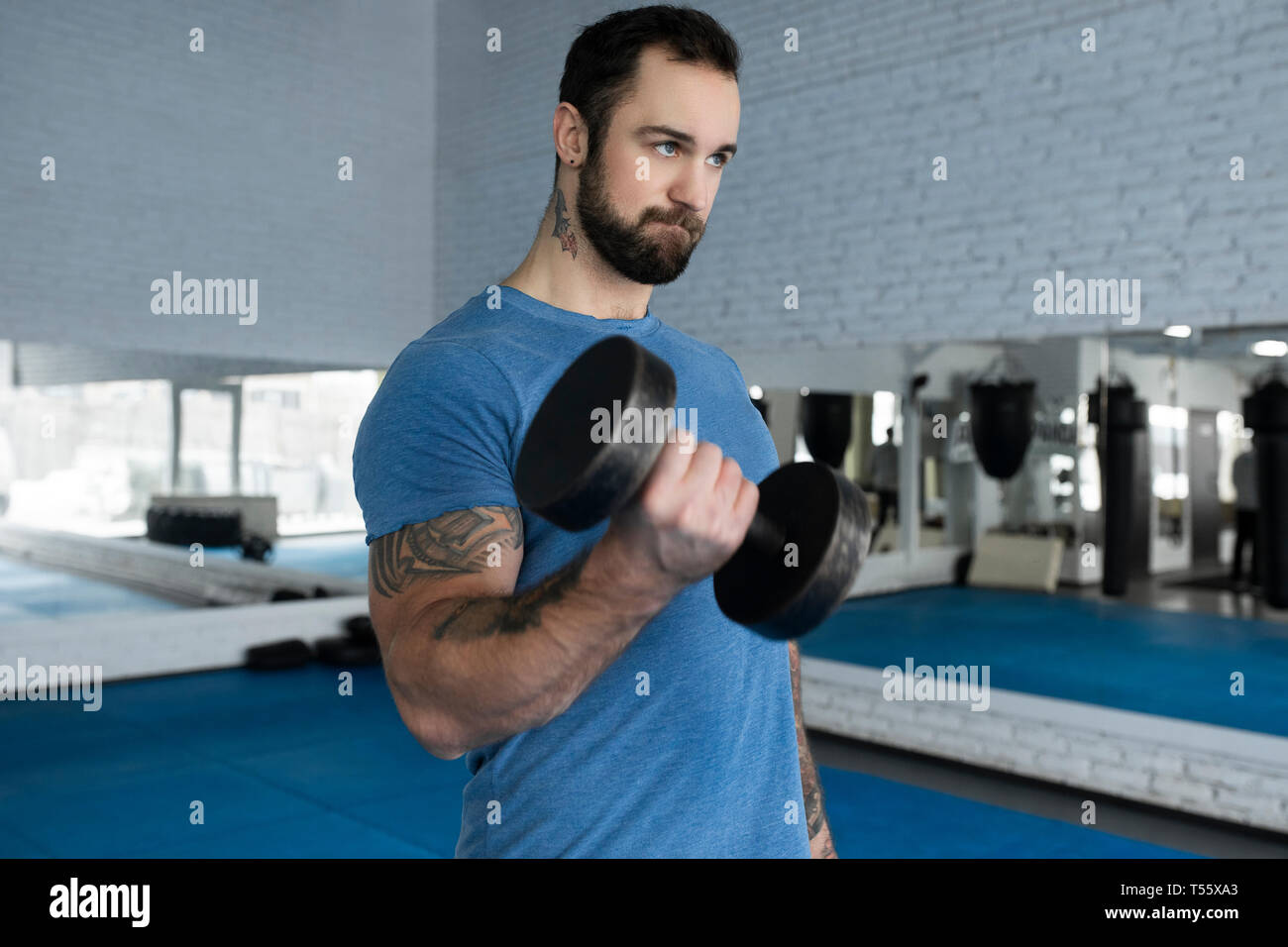 Mitad hombre adulto levantamiento pesa en el gimnasio Foto de stock