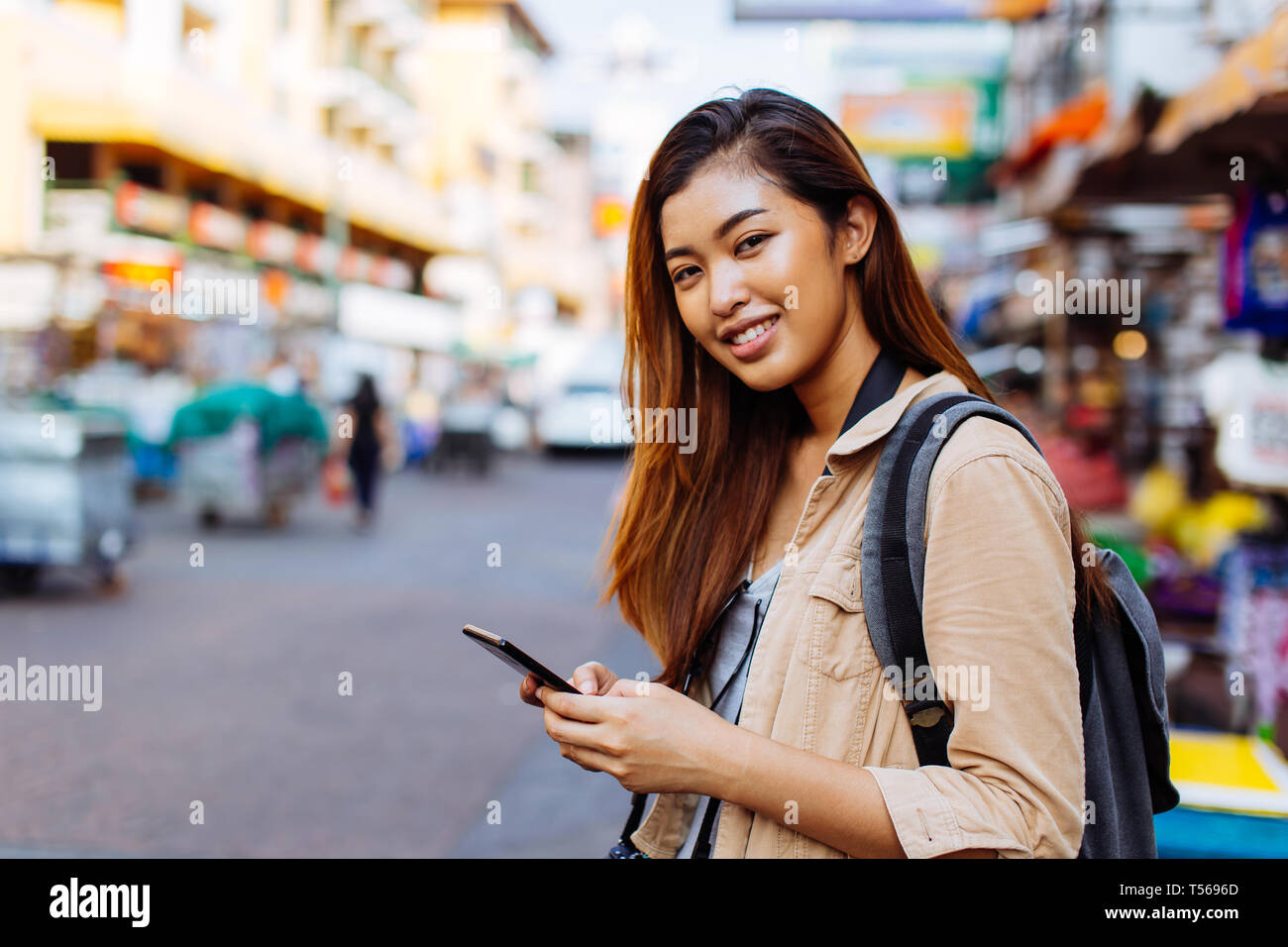 Jóvenes mujeres turistas asiáticos mujer utilizando un teléfono móvil en Bangkok, Tailandia. Llamar a un taxi o buscar información durante el viaje concepto Foto de stock