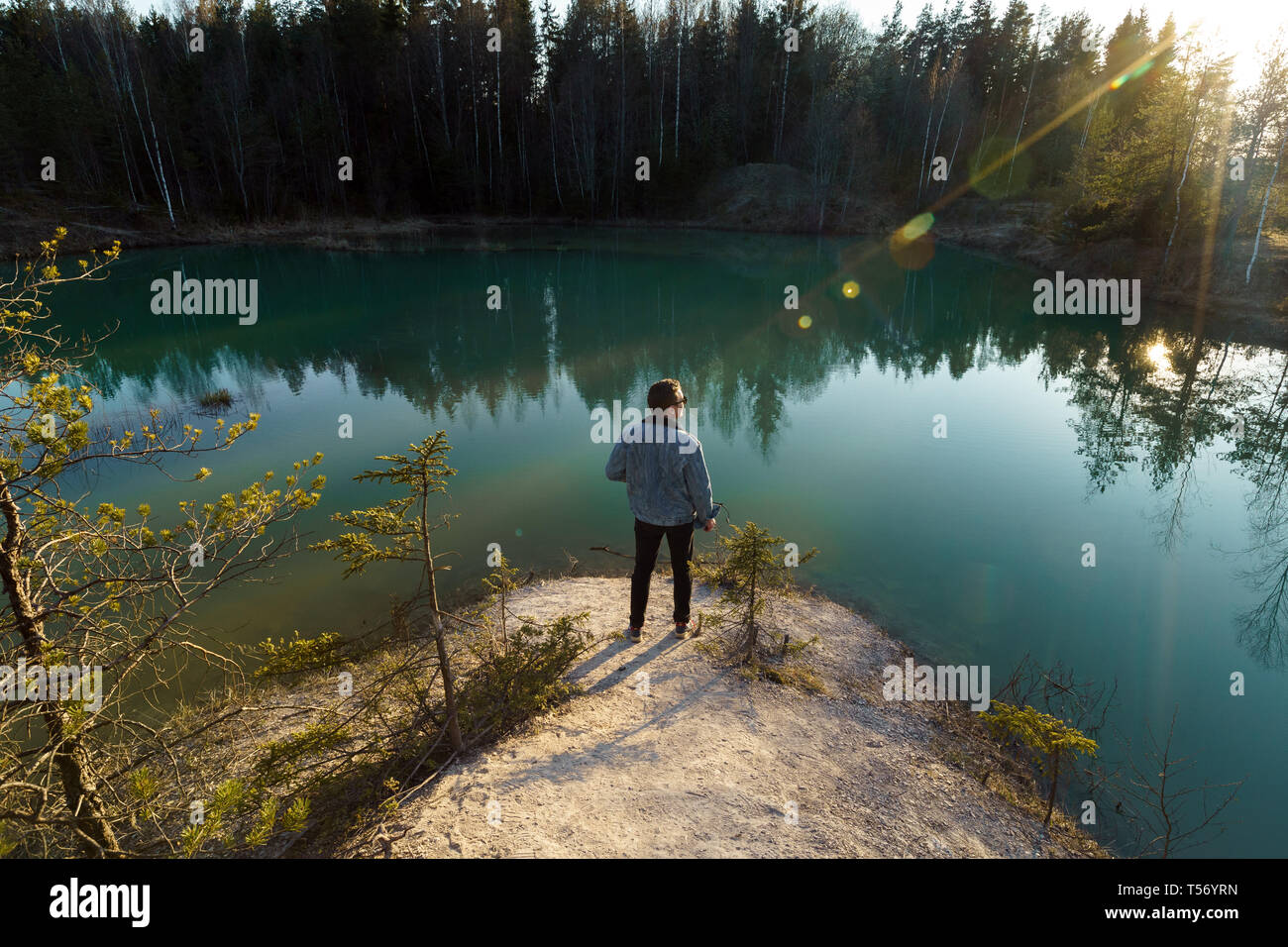 Joven tomar fotos de viajes - Hermoso lago Turquesa en Letonia - estilo Meditirenian colores en Estados bálticos - Lackroga ezers Foto de stock