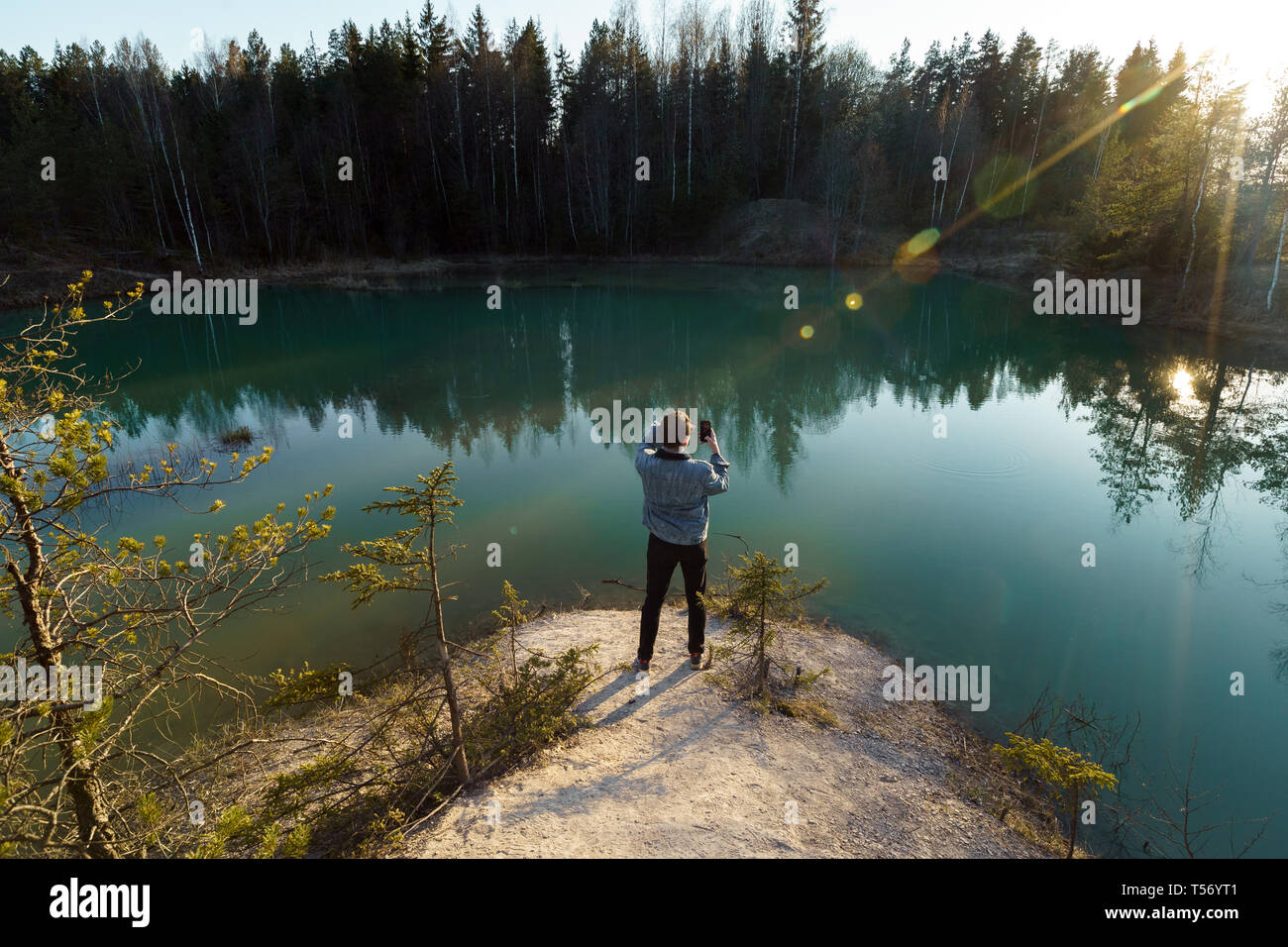 Joven tomar fotos de viajes - Hermoso lago Turquesa en Letonia - estilo Meditirenian colores en Estados bálticos - Lackroga ezers Foto de stock