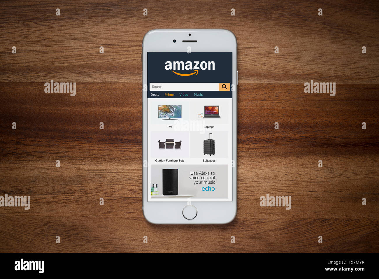 Un iPhone que muestra el sitio web Amazon descansa sobre una mesa de madera normal (uso Editorial solamente). Foto de stock