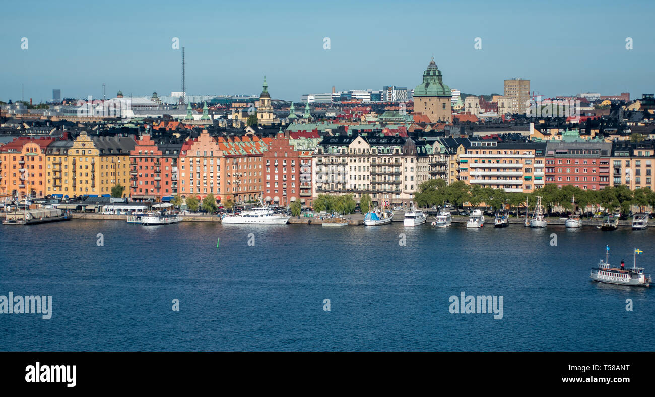 Los coloridos edificios de histroric Norr Mälarstrand mirando los ferries y barcos amarrados en el Lago Mälaren. Foto de stock