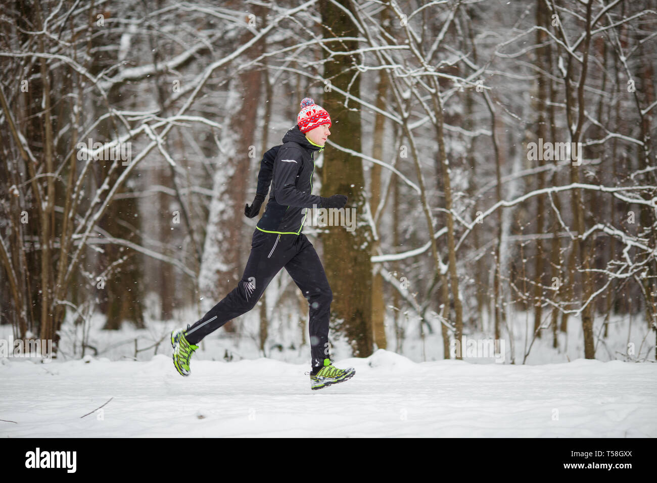 Desde el lado de la imagen del hombre en ropa deportiva, tapa roja en  correr en invierno Fotografía de stock - Alamy