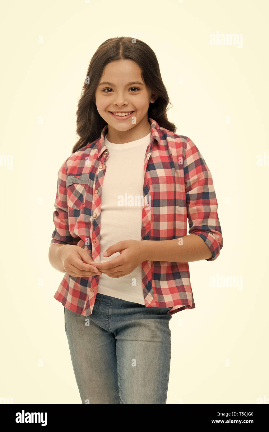 Despreocupada y casual. Chica linda camisa a cuadros y pantalón de mezclilla  parece feliz alegre. Niño niña despreocupada feliz disfrutar de la niñez.  Chico Chica de largo cabello rizado feliz alegre, aislado